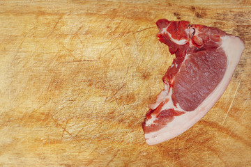 Raw pork meat on wooden cutting board taken closeup.Top view.