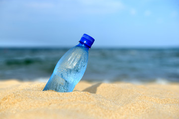 Wall Mural - Bottle of the fresh water on sand