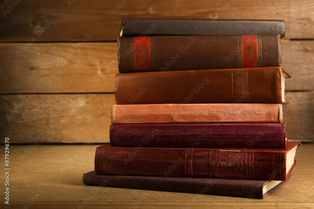 Old books on shelf, close-up, on wooden background