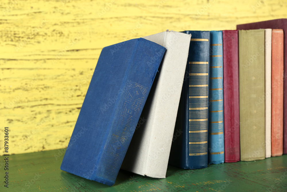 Retro books on yellow wooden background