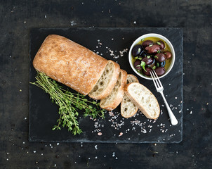 Italian ciabatta bread cut in slices on wooden chopping board