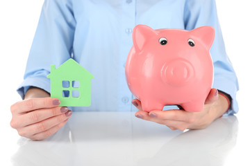 Canvas Print - Female hands holding piggy bank and house, closeup