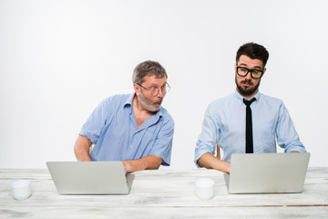 The two colleagues working together at office on white