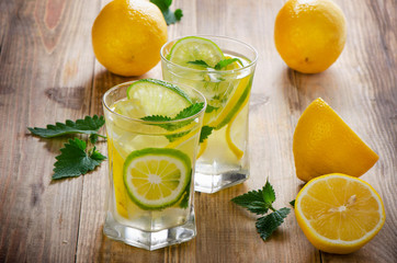 Lemon water with fresh lemons and green mint leaves.