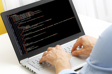 Wall Mural - programmer profession - man writing programming code on laptop c