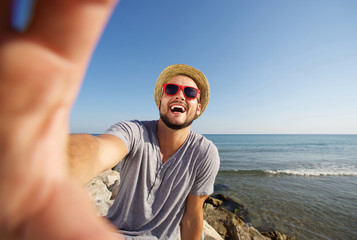 Sticker - Man on vacation laughing at the beach taking selfie