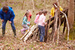 Adults And Children Building Camp At Outdoor Activity Centre