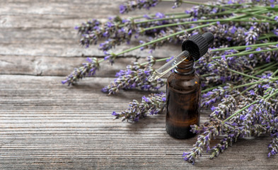 Canvas Print - Herbal oil and lavender flowers bouquet on wooden background