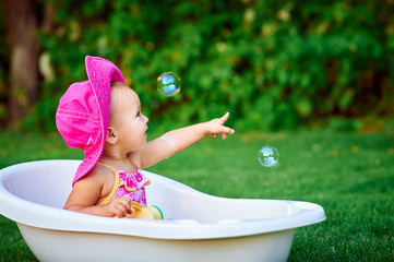little girl in a red hat bathed in the bath
