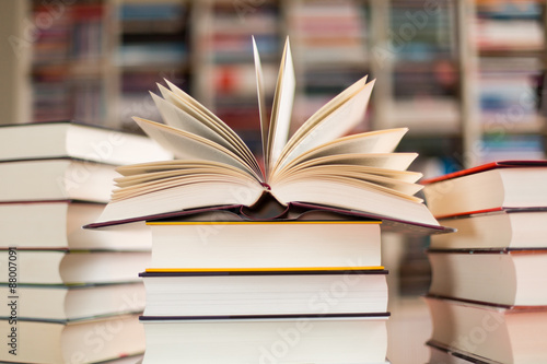 Aufgeschlagenes Buch auf Bücherstapel Tableau sur Toile