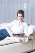© Jürgen Hüls - attractive woman reading on tablet on couch