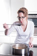 © Jürgen Hüls - attractive woman in modern ktchen cooking and tasting