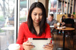 © sittinan - Happy entrepreneur working with a phone and tablet in a coffee shop in the street