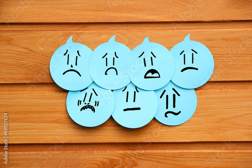 Fotografie, Obraz Sad emotions on blue stickers on wooden background