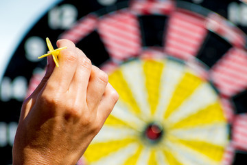 hand throwing a dart on a target