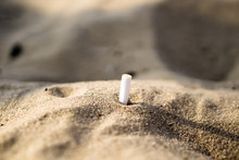 Smoked Cigarette In Sand Hill Macro Background