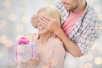 Poster - happy man giving woman gift box at home