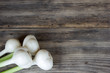 © Koirill - fresh garlic bulbs with long stalk on wood table with copy space