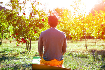 man meditates in garden