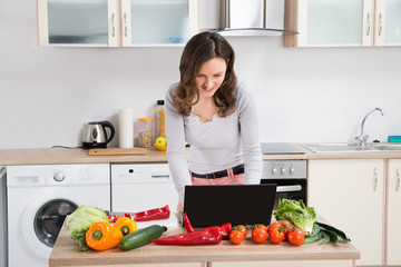 Wall Mural - Woman Looking For Recipe On Laptop