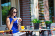 © travnikovstudio - Beautiful woman sitting in outdoors cafe at european city having