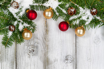 Wall Mural - Snow covered fir branches and ornaments on rustic white wooden b