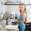 © JackF - female child cleaning dishware at home