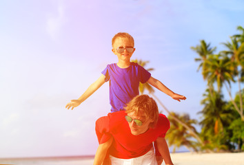 father and son playing on summer beach