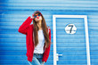 © zadorozhna - Outdoor fashion closeup portrait of nice pretty young hipster woman posing  on the background of blue wall on the streets