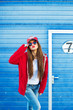 © zadorozhna - Outdoor fashion closeup portrait of nice pretty young hipster woman posing  on the background of blue wall on the streets