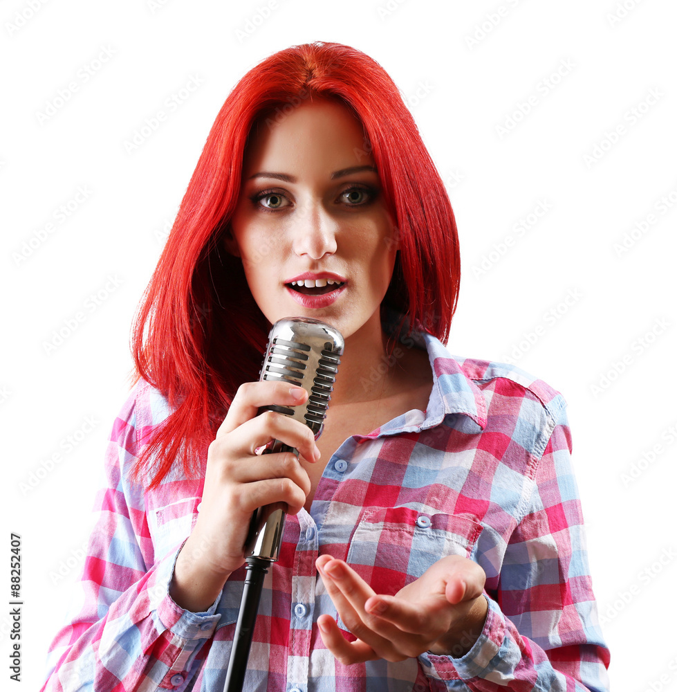 Beautiful young woman singing with microphone isolated on white