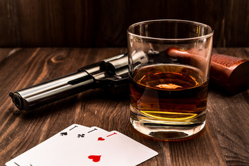 Wall Mural - Glass of whiskey and playing cards with revolver on the wooden table