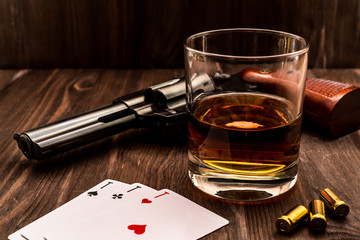 Wall Mural - Glass of whiskey and playing cards with revolver on the wooden table