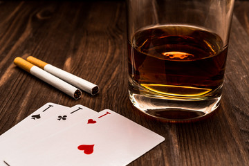 Wall Mural - Glass of whiskey and playing cards with two cigarettes on the wooden table