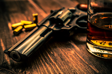 Wall Mural - Glass of whiskey with revolver on the wooden table
