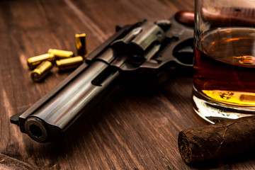 Wall Mural - Glass of whiskey with revolver and cuban cigar on the wooden table