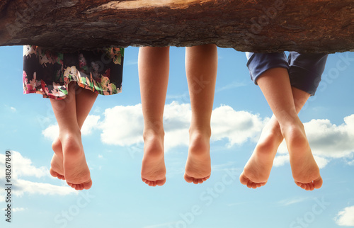 Fotomural Children sitting in a tree dangling their feet