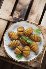 Sticker - Hasselback potatoes on a rustic wooden crate, view from above