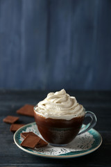 Wall Mural - Cup of coffee with cream on color wooden background