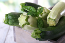Fresh Zucchini With Squash And Basil In Wooden Box On Bright Background