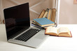 © Africa Studio - Laptop with books on table in room