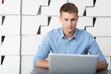 Sticker - junger mann sitzt am schreibtisch und arbeitet am laptop