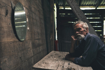 Wall Mural - Pensive Bearded Man Sitting Inside a Wooden House