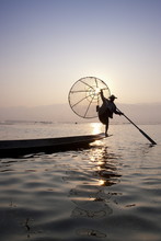 Intha Leg Rowing Fisherman At Dawn Silhouetted Against The Sun, Inle Lake, Nyaungshwe, Shan State, Myanmar (Burma), Asia 