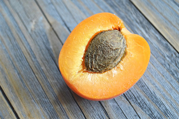 Wall Mural - A half of an apricot on wooden background