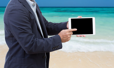 Wall Mural - Businessman hands holding tablet computer with seascape backgrou