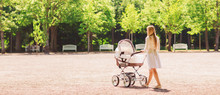 Happy Mother With Stroller In Park