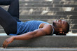 © mimagephotos - Smiling man lying down on back outside