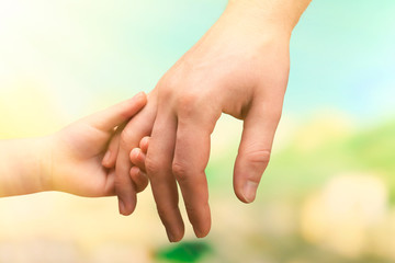 Wall Mural - Child and mother hands together on bright background