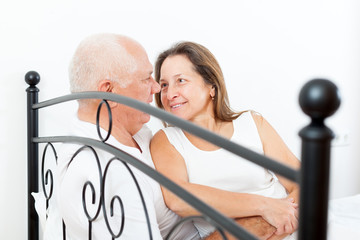 Sticker -  elderly couple embracing in bed.